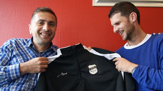 Ranko Jakovljevic (links) und Goran Ivelj mit einem Trainingsanzug mit Firmenlogo.