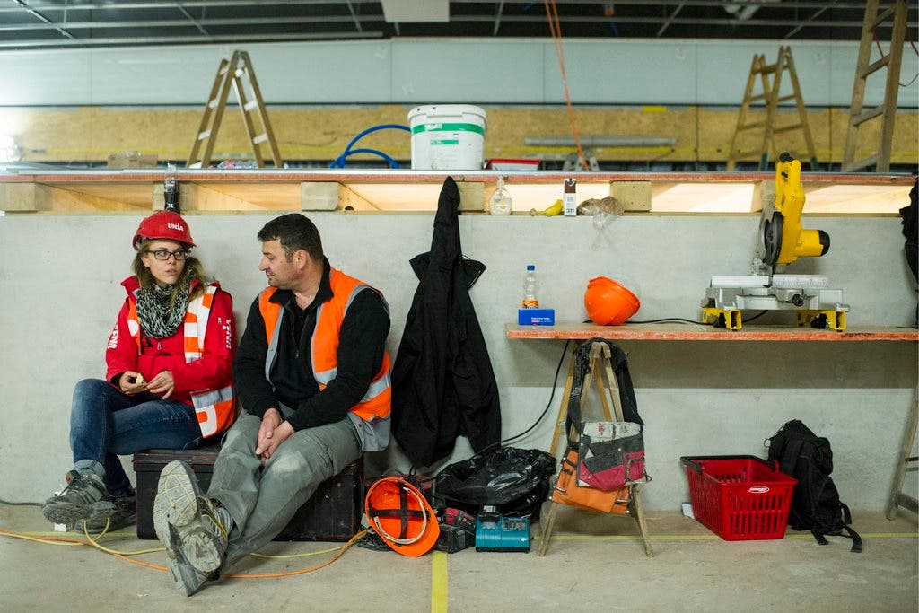 Eine Unia-Mitarbeiterin spricht mit einem Bauarbeiter am Streik auf der SBB Baustelle am Hauptbahnhof in Zürich
