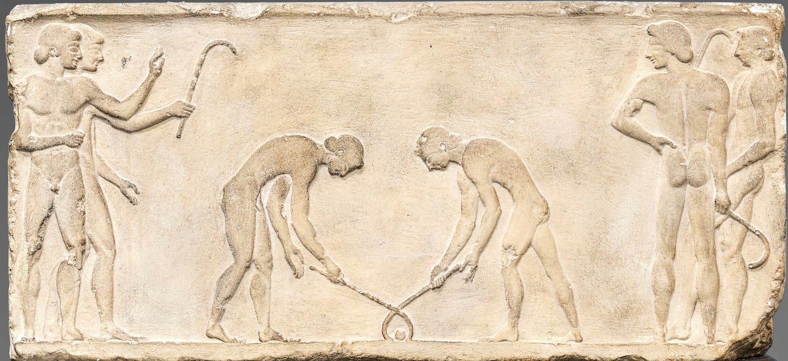 Dieses aussergewöhnliche Relief bezeugt als einziges für die Antike eine Art Hockey-Spiel, wohl das in den Schriftquellen überlieferte keretizein. Relief von einer Statuenbasis; Marmor; um 510/500 v. Chr.; Athen, Archäologisches Nationalmuseum (Original); Abguss