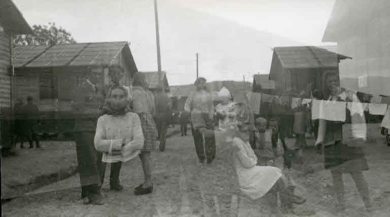 Flüchtlinge auf der Strasse im Barackenlager (doppelt belichteter Film), 1945