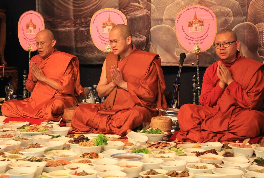  Die Besucher der Zeremonie haben ihr mitgebrachtes Essen in Dutzenden Schalen vor die Mönche gelegt.