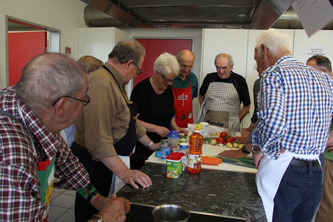 Die Senioren schauen der Kochkursleiterin aufmerksam zu