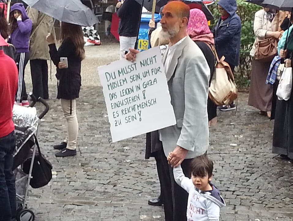 Demonstrant protestiert in Aarau, mit Kind und Plakat.