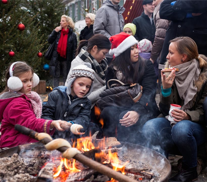 Wie bei den Pfadi: Kinder backen am Münsterplatz-Weihnachtsmarkt Schlangenbrot.