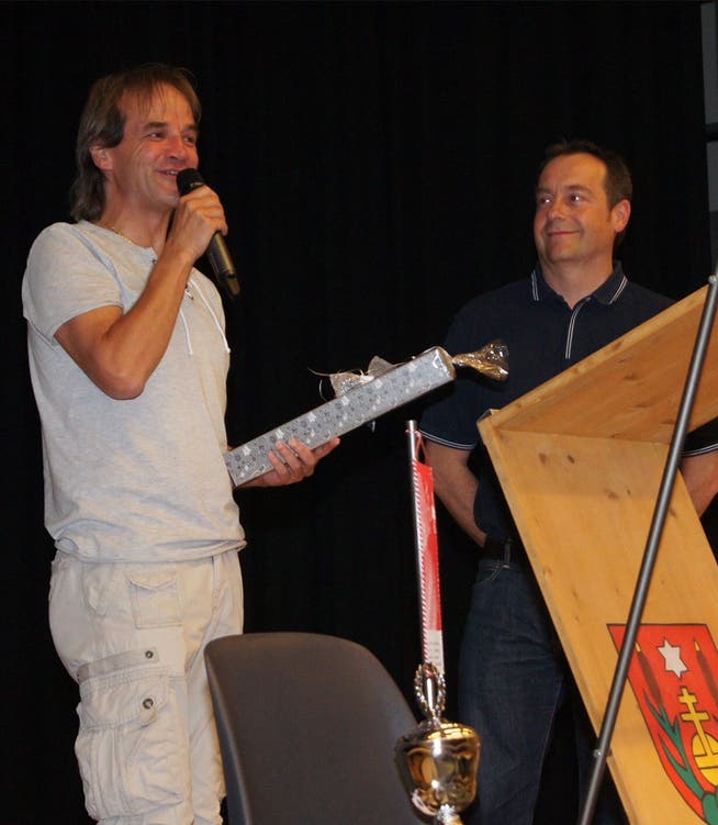 Marc Grenacher von der Polterzunft Staretschwil (links) übergibtGeschenke an den Vereinspräsidenten Rolf Gasser.