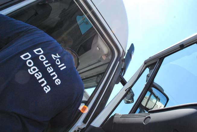 Ein Zöllner kontrolliert in Rheinfelden einen LKW-Fahrer