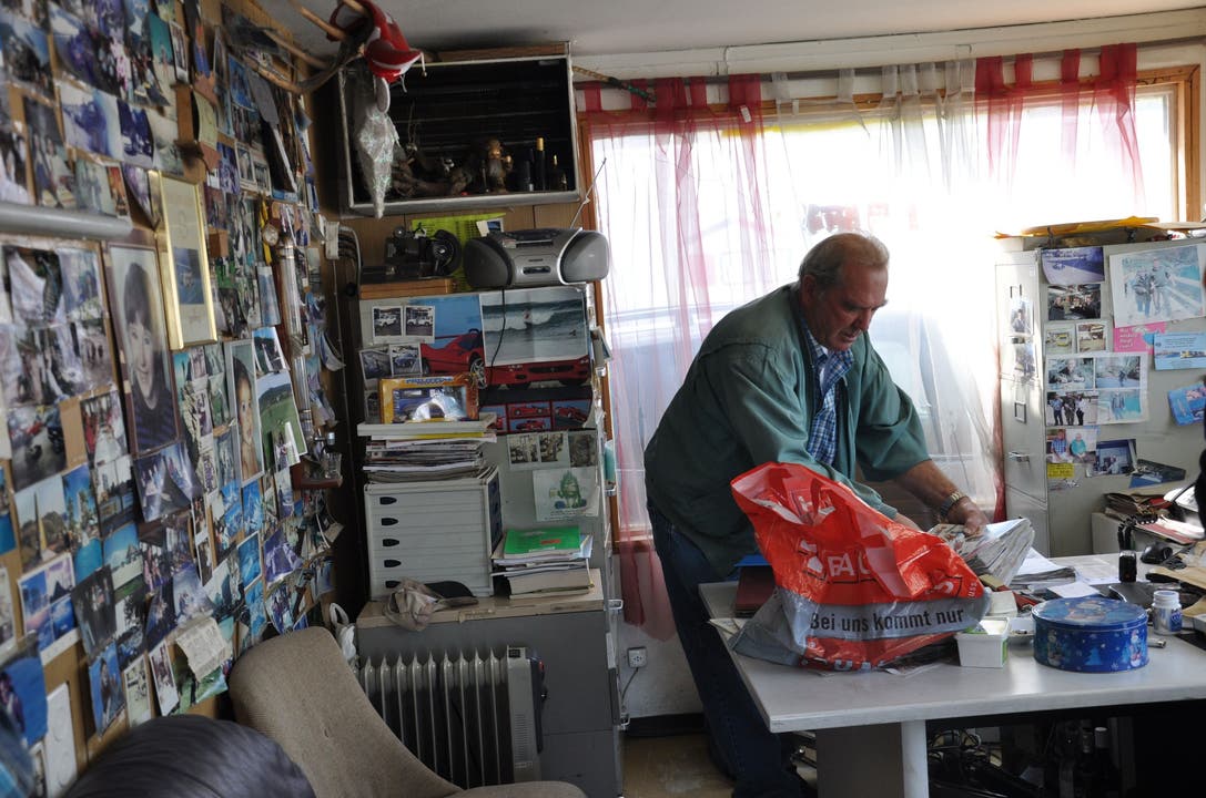 Der Garagist Hans Brügger steht in seinem Büro und sucht seine Versicherungsunterlagen zusammen