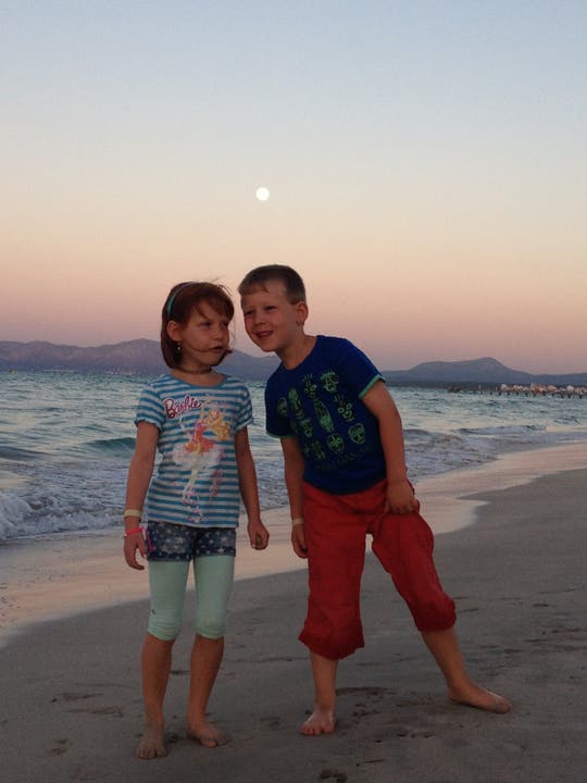 Joelle und Andrin Meyer aus Muri, geniessen den Sonnenuntergang am Strand von Alcúdia Mallorca.