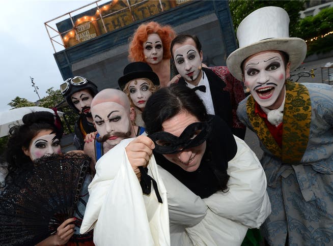 Sängerin Erika Stucky (mit Maske und Schlafsack-Mantel) posiert mit den Vaudeville-Schauspielern auf dem Theaterplatz.