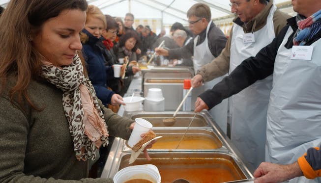 Mitglieder des Rotary Clubs verteilen Suppe an die Gäste im Zelt auf dem Wettinger Zentrumsplatz.