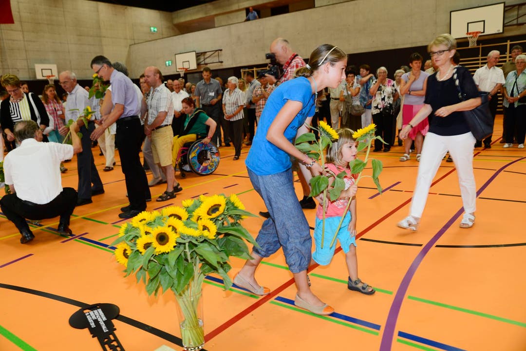 Kinder und Erwachsene schmückten am Festakt vom Sonntag die neue Biberister Dreifach-Sporthalle mit Sonnenblumen.