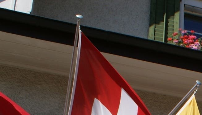 Die Banner von Gemeinde, Nation und Kanton flattern wieder vereint an der Fassade des Gemeindehauses.