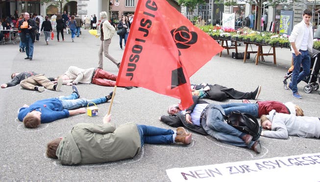 Rund 10 Personen der JUSO Aargau legten sich auf den Boden und liessen den Umriss ihrer Körper mit Kreide nachzeichnen.