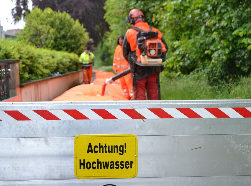Mitarbeiter des Aarauer Stadtbauamtes montieren Hochwassersperren am Ufer der Aare.