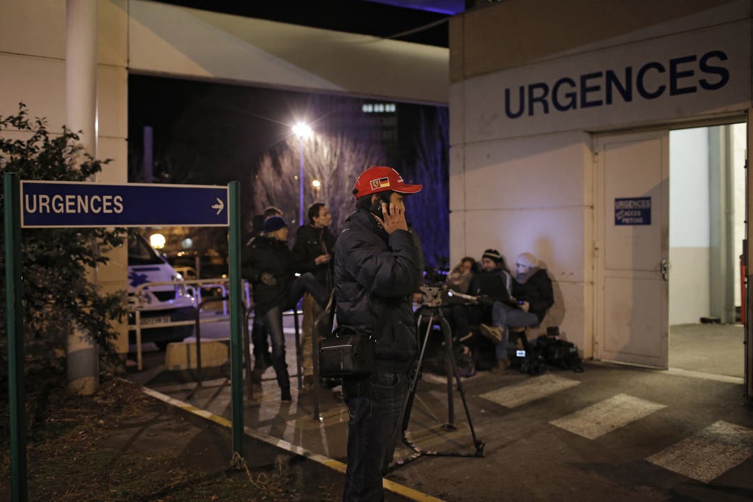 Ein Schumacher-Fan wartet vor dem Krankenhaus in Grenoble auf weitere News von seinem Idol.