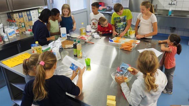 Die Kinder lernen, wie man eine brasilianische Rüeblitorte und Käsebällchen herstellt. Bruno Kissling