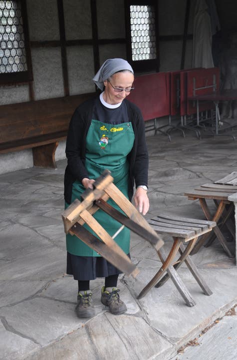 Schwester Christa bereitet die Stühle für den Transport vor