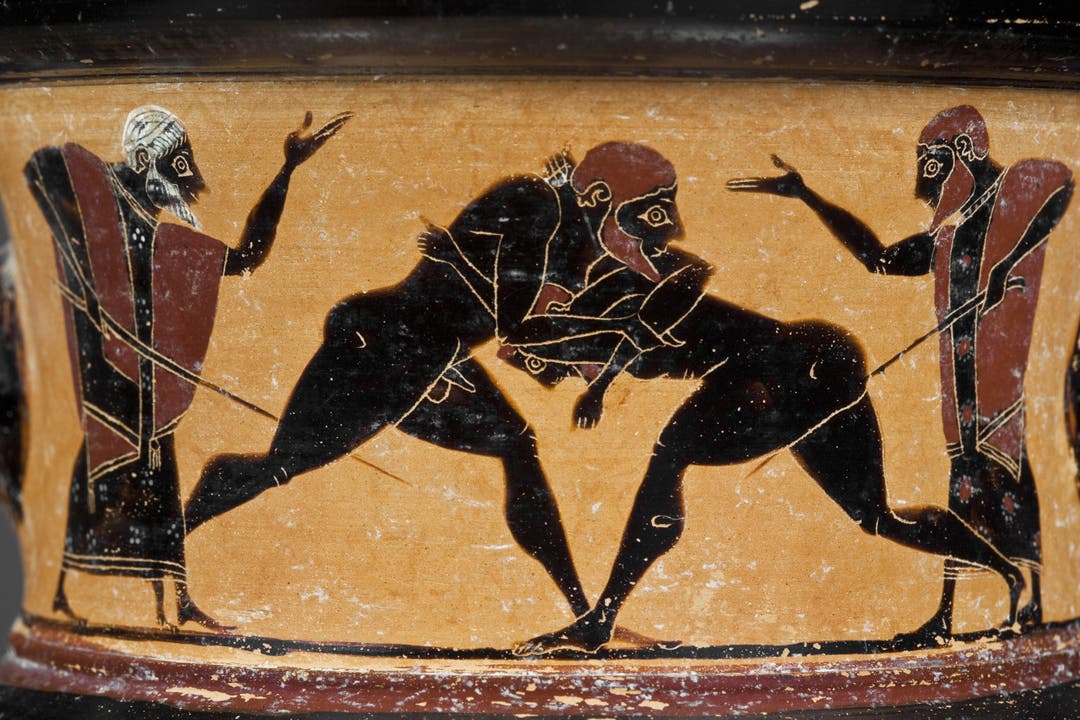 Szene aus einem antiken Ringkampf. Coaches geben den beiden Ringern mit einer Gerte Anweisungen. Weingefäss (Amphora) aus Athen; Ton; um 550 v. Chr.