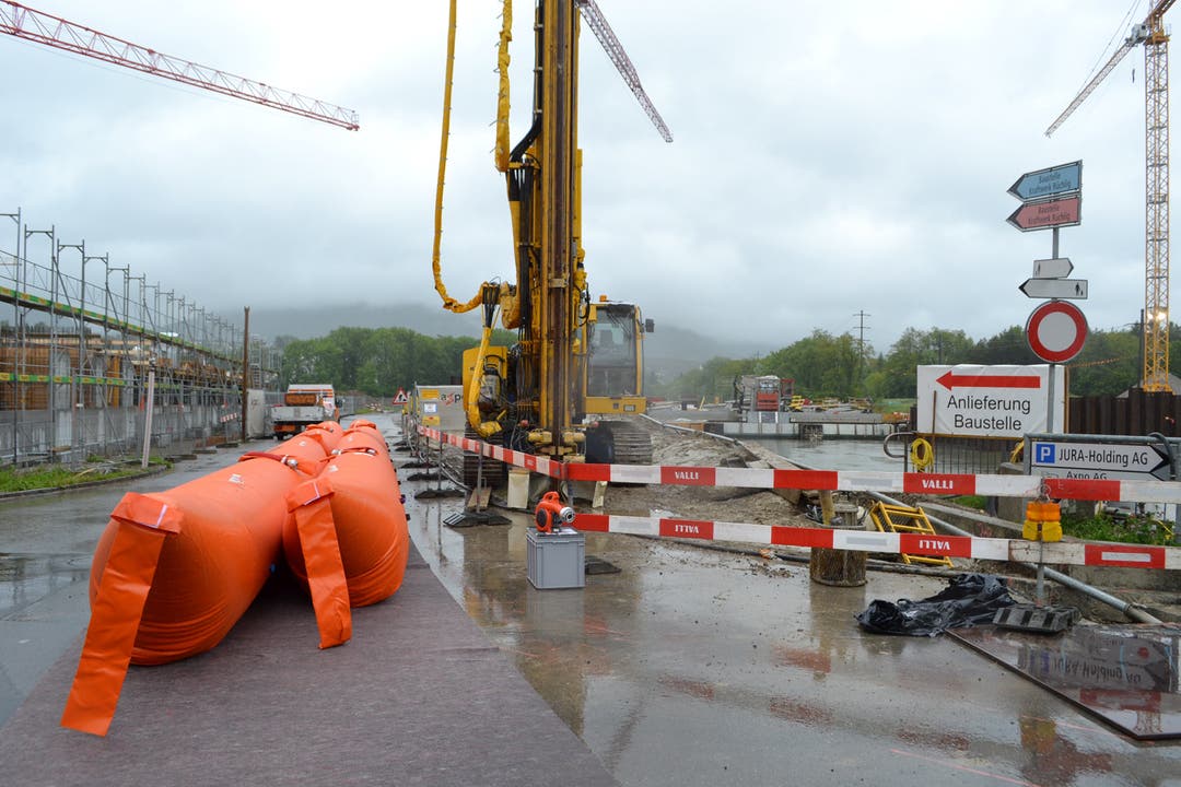Mitarbeiter des Aarauer Stadtbauamtes montieren Hochwassersperren am Ufer der Aare.