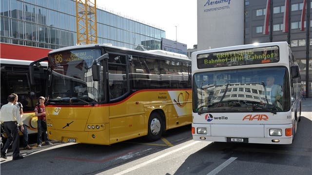 Gelbe Postautos fahren weiterhin auch in Aarau, hier vor dem Bahnhof. Daneben ein weisser Bus der regionalen Verkehrsbetrieb AAR bus+bahn.