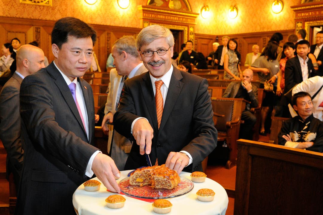 Carlo Conti (r.) und der chinesische Botschafter Ken Wu (l.) schneiden als zeremonielle Eröffnung der Chinaworld 2010 den Mondkuchen an.
