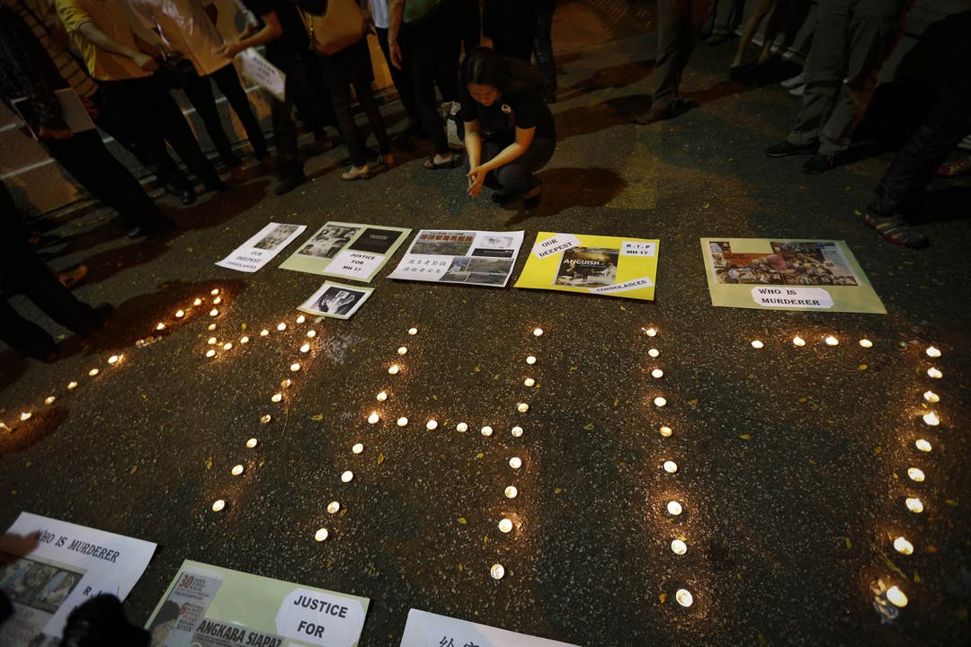 «Wer ist der Mörder?» steht auf einem Karton - grosse Trauer in Kuala Lumpur.