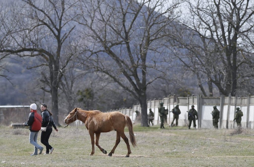 Frauen führen ein Pferd aus der übernommenen ukrainischen Militärzone nahe Simferopol.