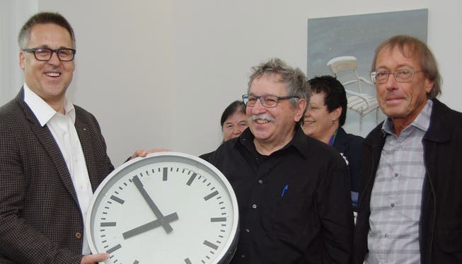Gemeindeammann Lukas Keller überreicht eine Uhr, die er auf der Baustelle fand, den Architekten Otto Tschampion und Felix Müller (v. l.).