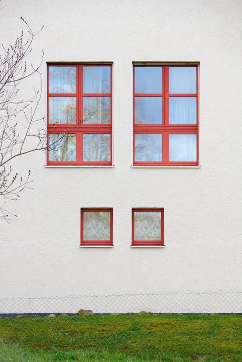 Rote Fensterrahmen treffen Besucher an der Pilgerstrasse an.