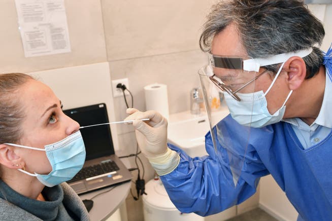 Ein Apotheker testet eine Frau mittels eines Schnelltests auf das Coronavirus. 