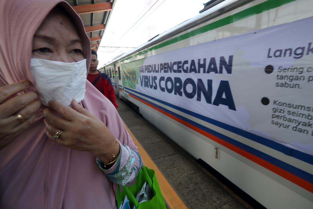 6. März: Ein Passagier der indonesischen Pendlerlinie trägt eine Maske, als sie an einem Banner mit der Aufschrift „Corona Virus Prevention“ in einem Zug der Rail Clinic am Bahnhof Depok in Depok vorbeigeht