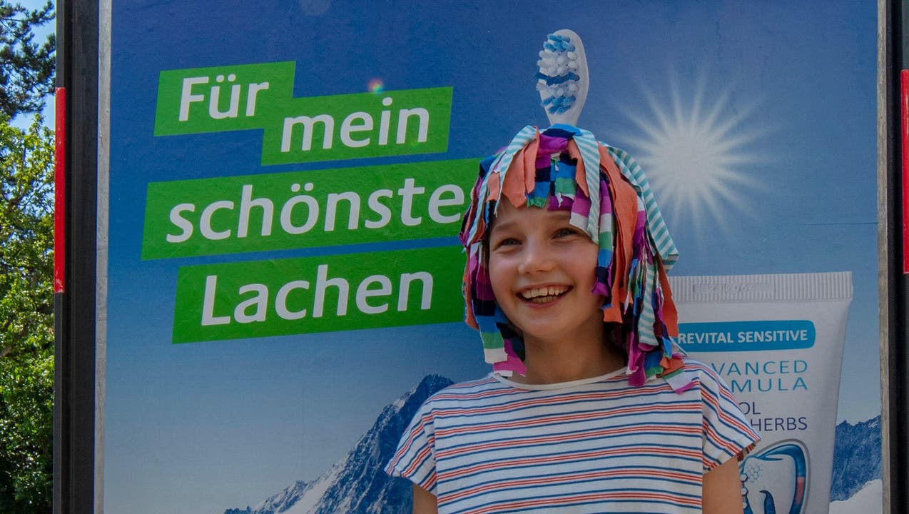 Eine der Lampefieber-Kursbesucherinnen vor ihrem Poster mit selbstgemachten Kopfschmuck (Bild Urs Dätwiler)1
