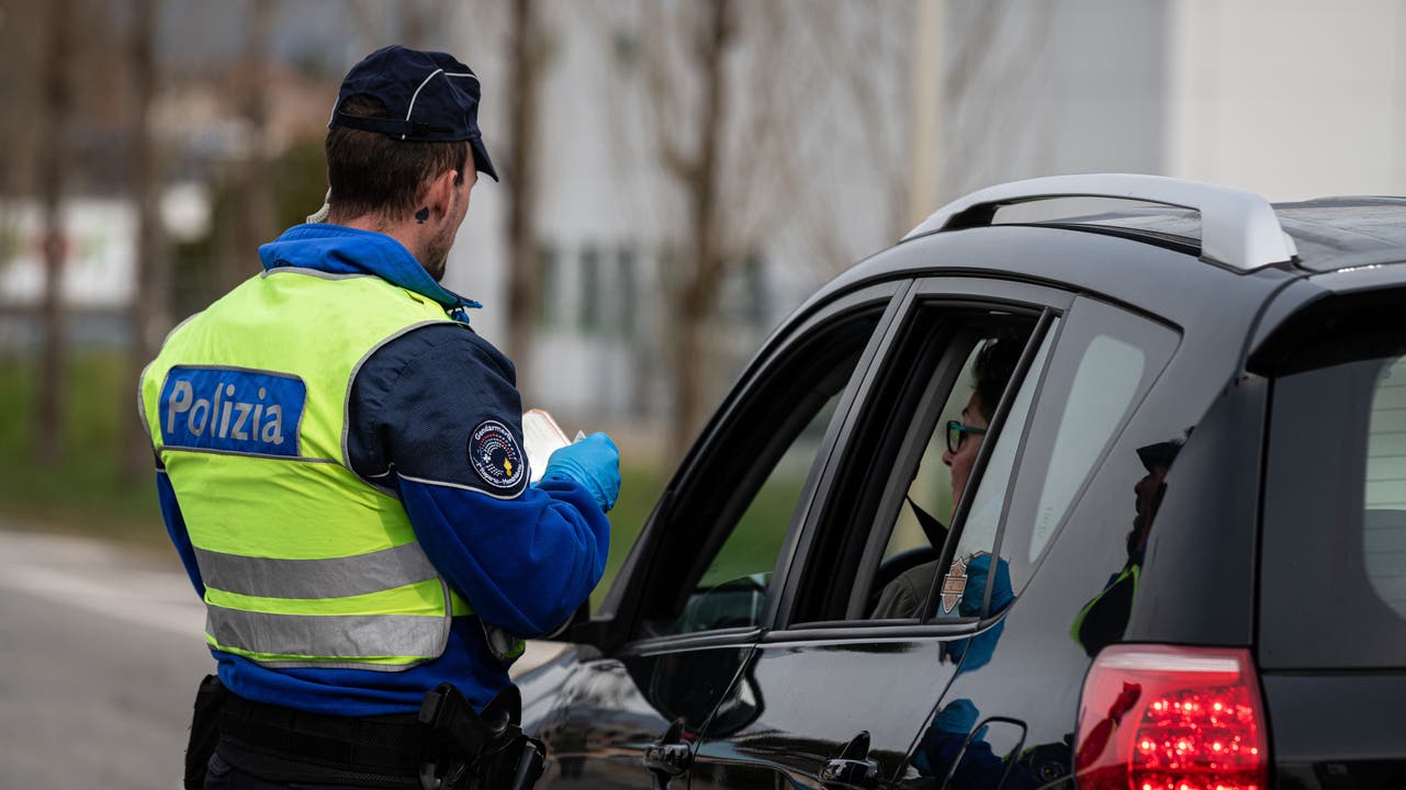 Ein Tessiner Kantonspolizist kontrolliert eine Grenzgängerin in Stabio.