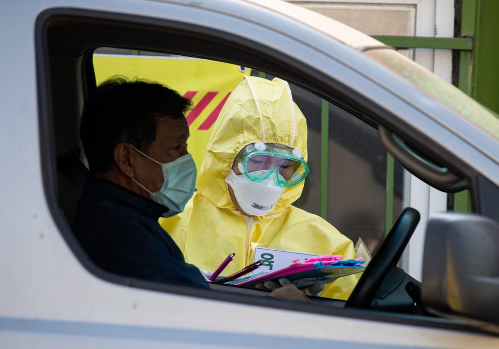 6. März: Ein medizinischer Mitarbeiter in Schutzkleidung bereitet sich in Seoul (Südkorea) darauf vor, einem Besucher in einem Durchfahrtszentrum Proben für das neuartige Coronavirus zu entnehmen.