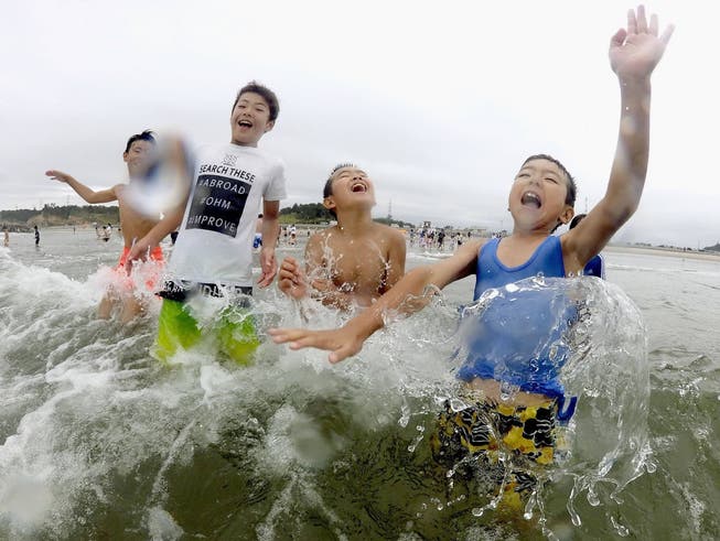 Kinder planschen erstmals seit acht Jahren wieder am Strand von Minamisoma.Bild: Imago Images