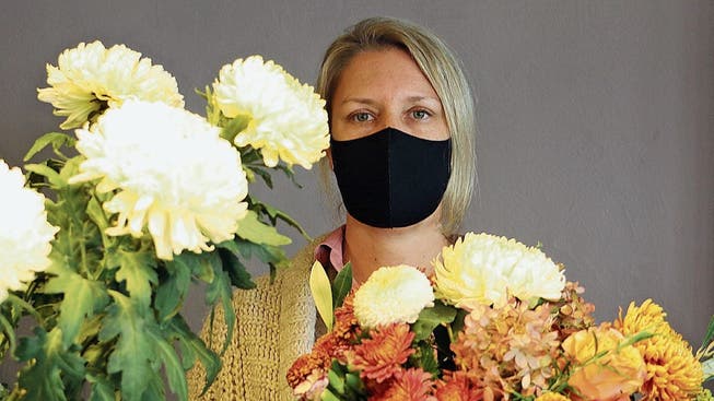 Isabelle Bolinger führt einen Blumenladen und hilft ihren Kunden mit Gratis-Masken aus.