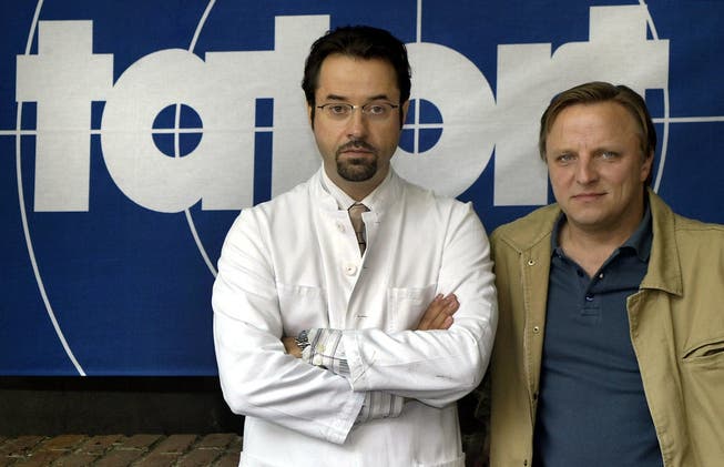 Die Schauspieler Axel Prahl, rechts, und Jan Josef Liefers, links, posieren vor einem Tatort-Logo. (Archivbild 2002).