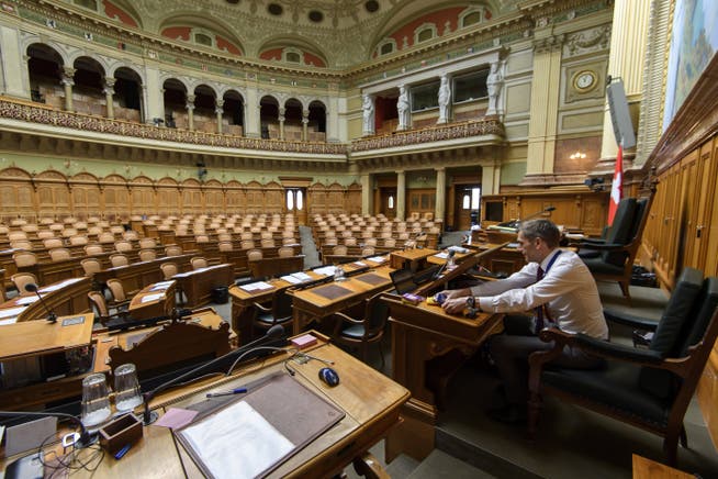 Leere Reihen im Nationalratssaal: Philippe Schwab, Generalsekretär der Bundesversammlung, packt seine Sachen. Die Session ist abgesagt.