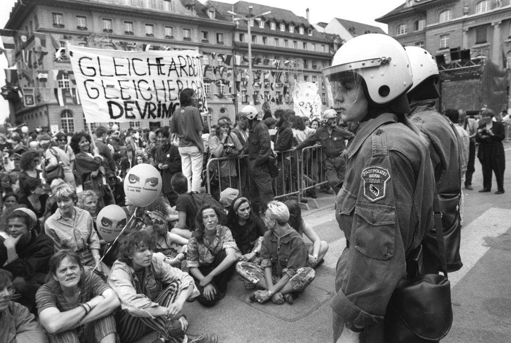 28 Jahre zuvor beim ersten Frauenstreik stand die Politik den Frauen weniger gutmütig gegenüber – Auf dem Berner Bundesplatz überwachten Polizisten mit strenger Haltung das Geschehen.