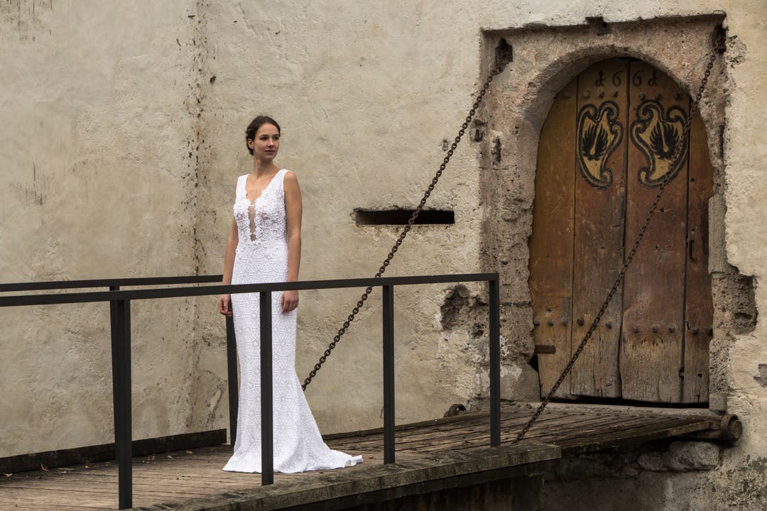 Ein Model posiert in einem Kleid von Nadine Willi vor historischer Kulisse.