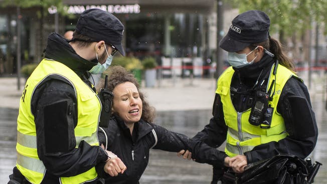 Polizisten verhaften eine demonstrierende Lockdown-Gegnerin auf dem Sechseläutenplatz in Zürich.