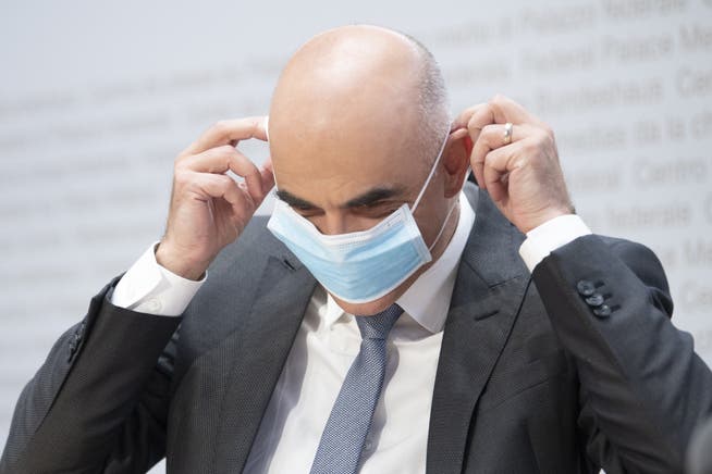 Bundesrat Alain Berset, zieht sich die Schutzmaske an. Während der Medienkonferenz vom vergangenen Freitag hat er die wöchentliche Verdopplung der Infektionen vorausgesagt.