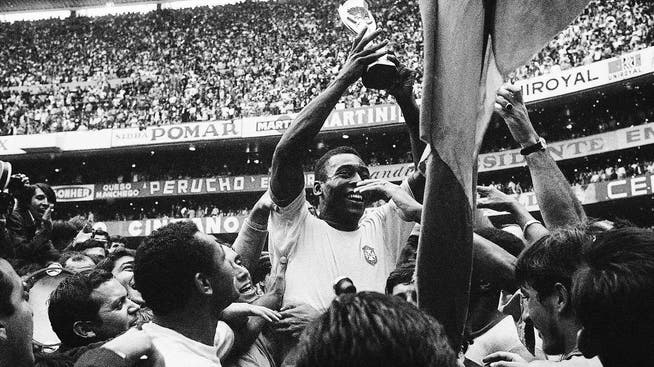 Pelé (M.) stemmt den Pokal nach dem Gewinn seines dritten Weltmeistertitels 1970.