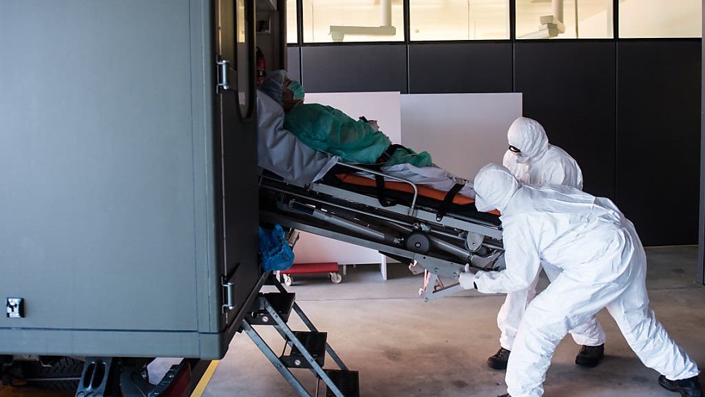 Das Tessin ist landesweit am stärksten vom Coronavirus betroffen: Soldaten der Schweizer Armee beim Transport eines Patienten mit Covid-19 am Eingang der Notaufnahme im Kantonsspital ''La Carita'' in Locarno.