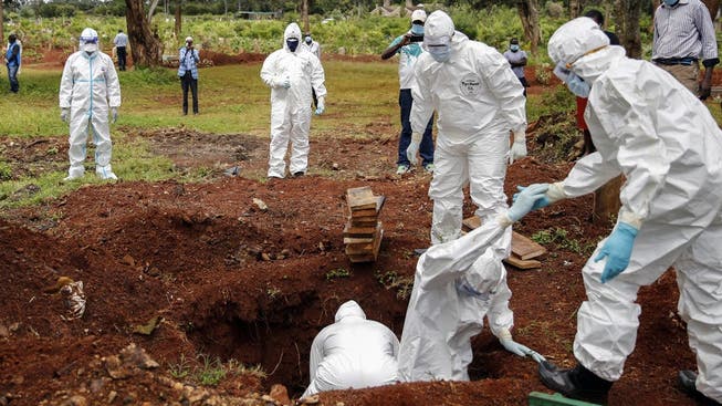 Bestattungsbeamte in Schutzkleidung beerdigen ein Coronavirus-Todesopfer auf dem Langata-Friedhof in Nairobi, der Hauptstadt Kenias. (Symbolbild.)