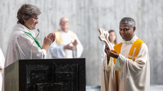 Edith Rey, Regionalverantwortliche des Bistums Basel, überreicht dem neuen Pastoralraumleiter Danam Yammani ein Willkommensgeschenk in Form eines Holzkreuzes.