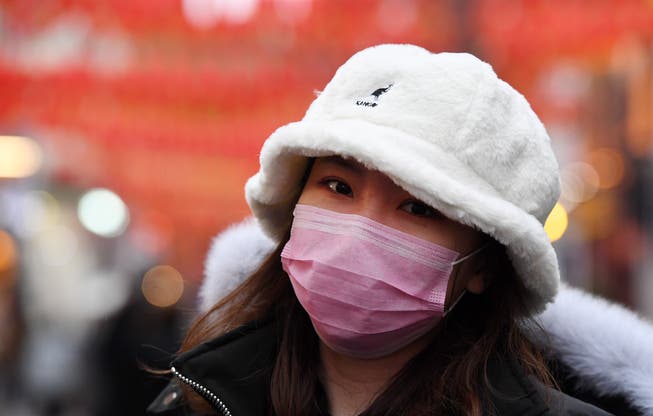 Das Virus sorgt Weltweit für Angst. Hier eine Frau, die sich mit einer Gesichtsmaske schützt, in London. EPA/ANDY RAIN
