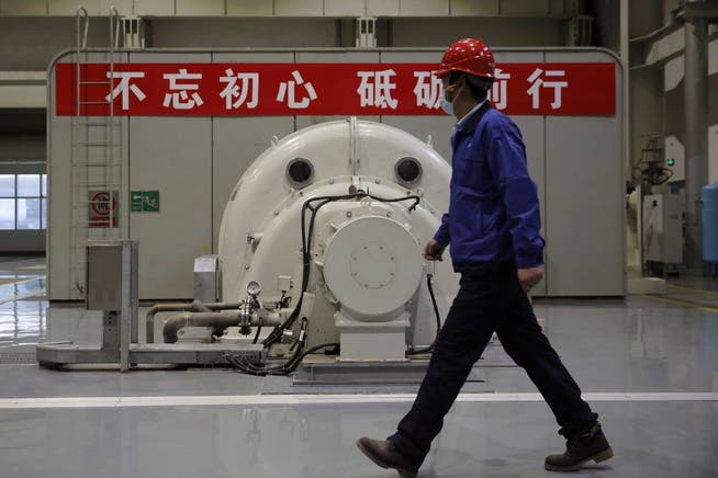 Ein Angestellter in einem chinesischen Produktionsbetrieb mit einer Schutzmaske.
