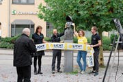 Der Fotograf und die vier Repräsentanten Branka Miljanovic, Marcel Koch, Sabine Keller und Samuel Schoeb (von links nach rechts) mit der eingehüllten Statue von Ulrich Bräker. (Bild: Flurina Lüchinger)