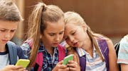Alle haben ein Smartphone: Auch Kinder nutzen bereits Whatsapp. Bild: Getty